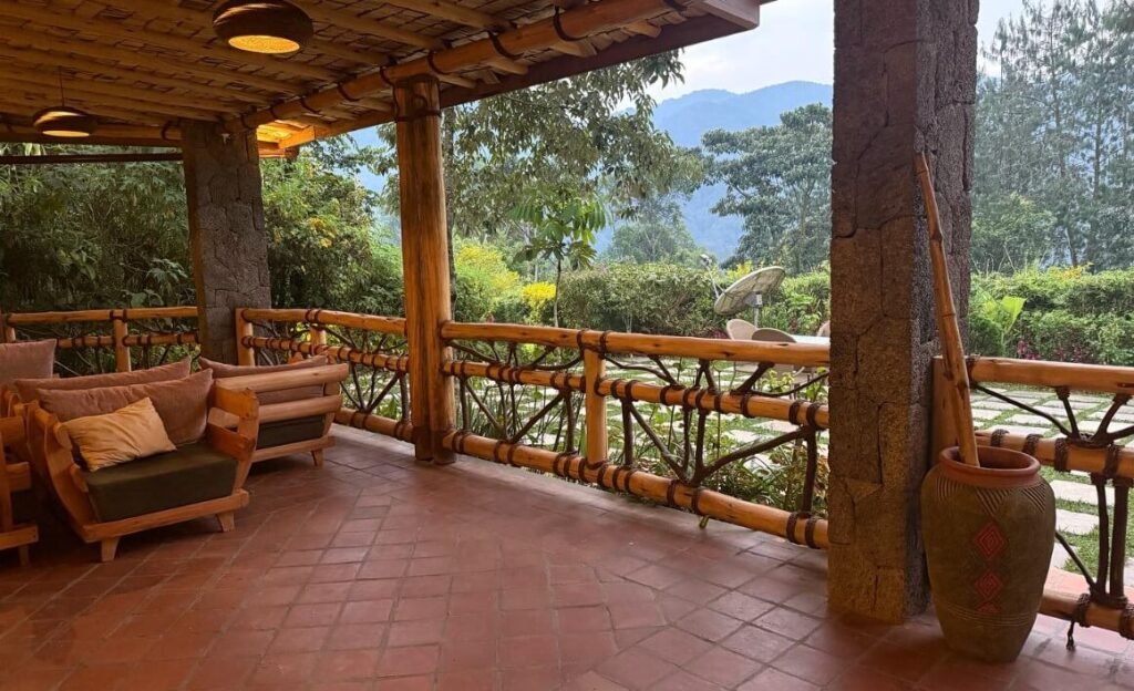 A wide, covered wooden porch with comfortable seating overlooking the forest in the Rushaga sector.