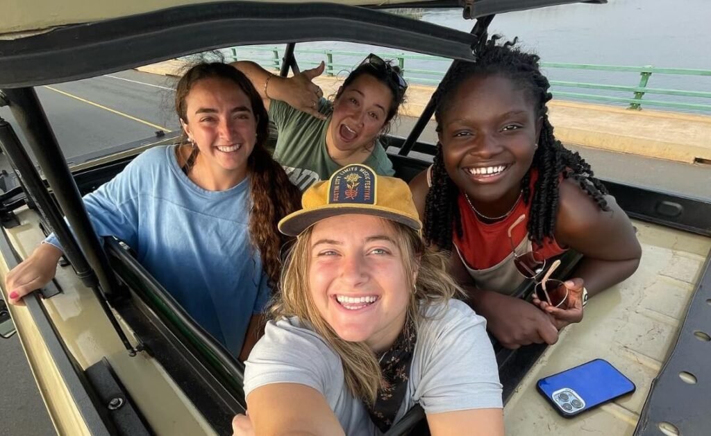 Happy tourists leaning out of a safari jeep on a Uganda wildlife safari
