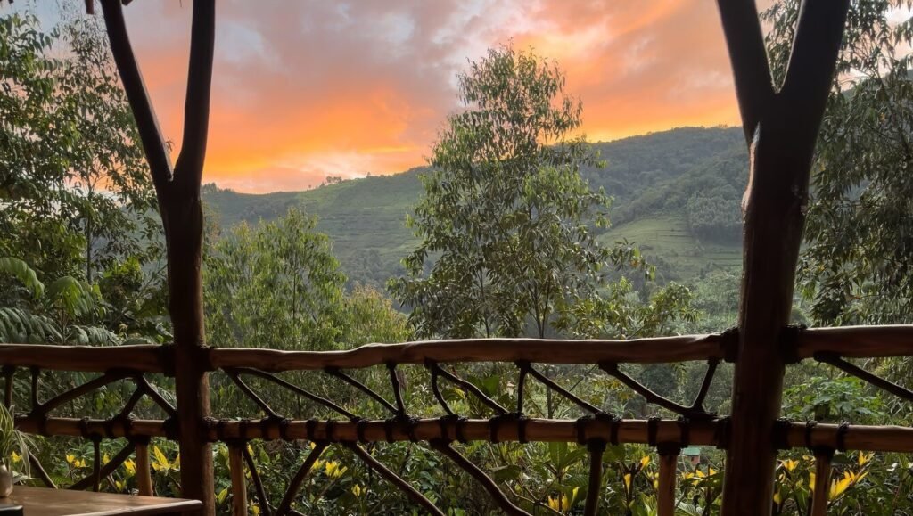 A sunset view from a safari lodge balcony overlooking the mist-covered mountains of southwestern Uganda.