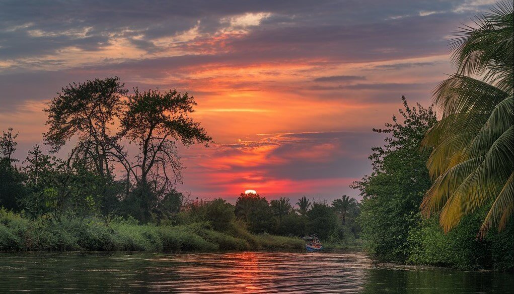 A vivid orange sunset over the Nile River corridor in Murchison Falls National Park, Uganda