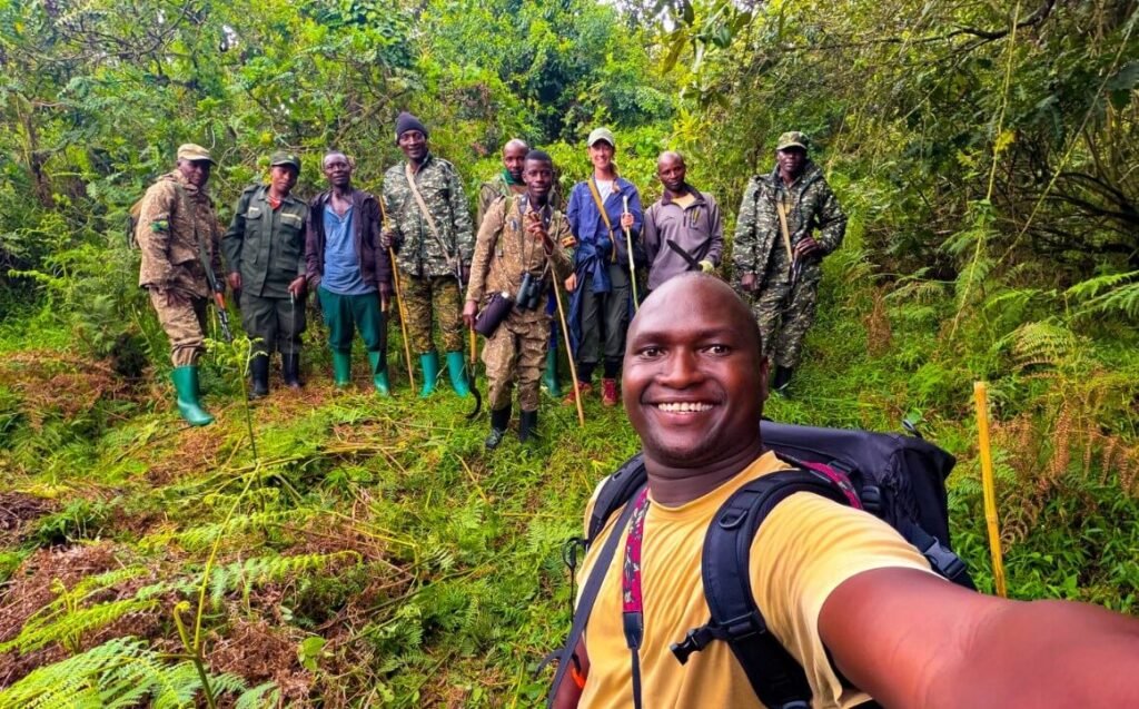 A group of tourists and local trackers posing in the lush forest during a gorilla safari in Uganda.