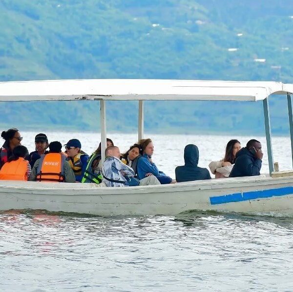 A group of travelers enjoying a boat ride on Lake Bunyonyi during a Ugandan safari.