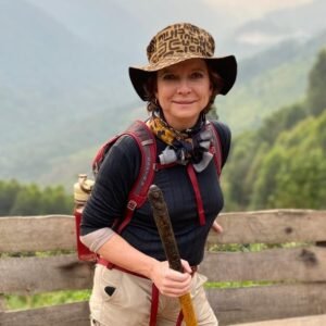 A female traveler wearing a sun hat and hiking gear, showing what to wear for gorilla trekking.