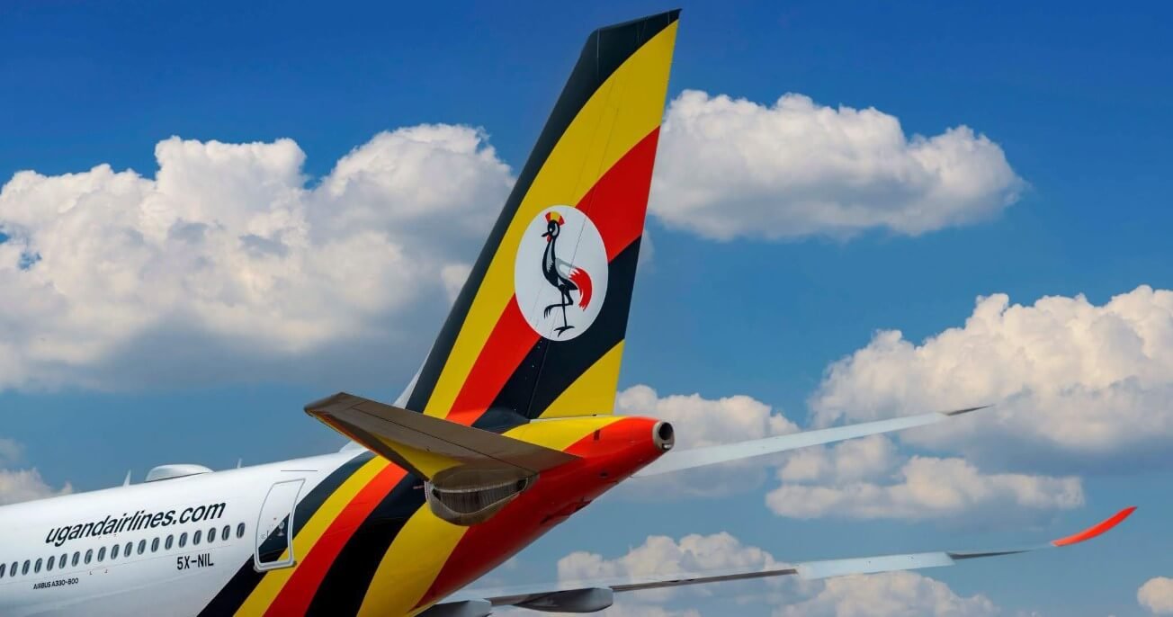 Uganda Airlines tail fin against a blue sky with clouds