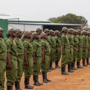 A disciplined line of Virunga National Park rangers in green uniforms standing at assembly during a morning briefing.