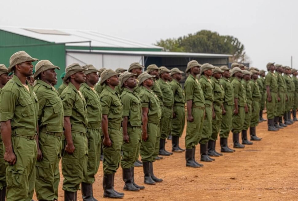 A disciplined line of Virunga National Park rangers in green uniforms standing at assembly during a morning briefing.